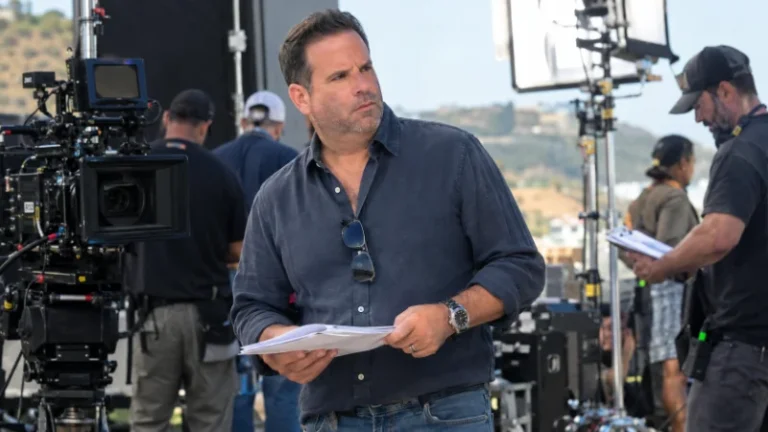Randall Emmett standing on a film set reviewing a shot with crew members nearby