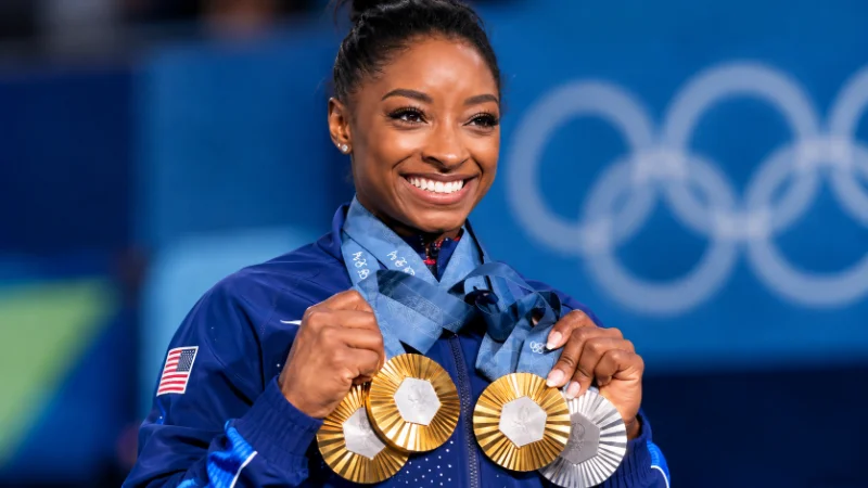 Simone Biles holding an Olympic medal